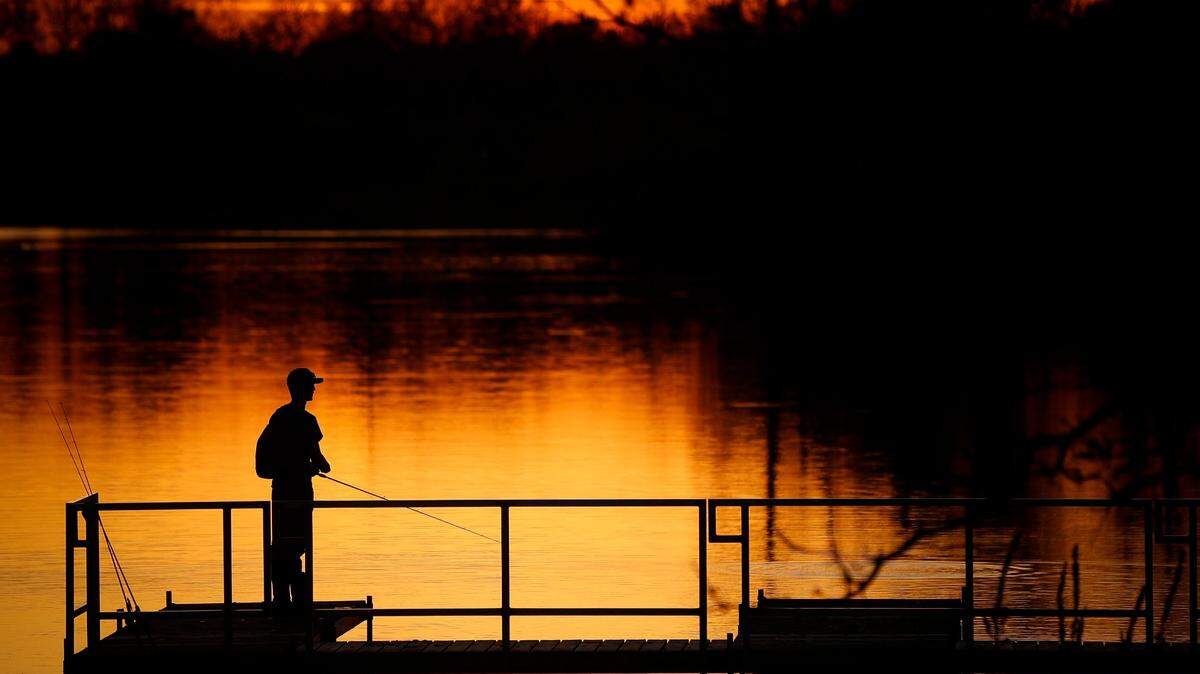 Garrett Mayfield, of Owensboro, Ky., an engineering student at the University of Kentucky, waits for a bite while fishing for catfish for the first time from a dock at Jacobson Park in Lexington, Ky., Friday, April 16, 2021. This weekend Kentucky offers free, permitless fishing.