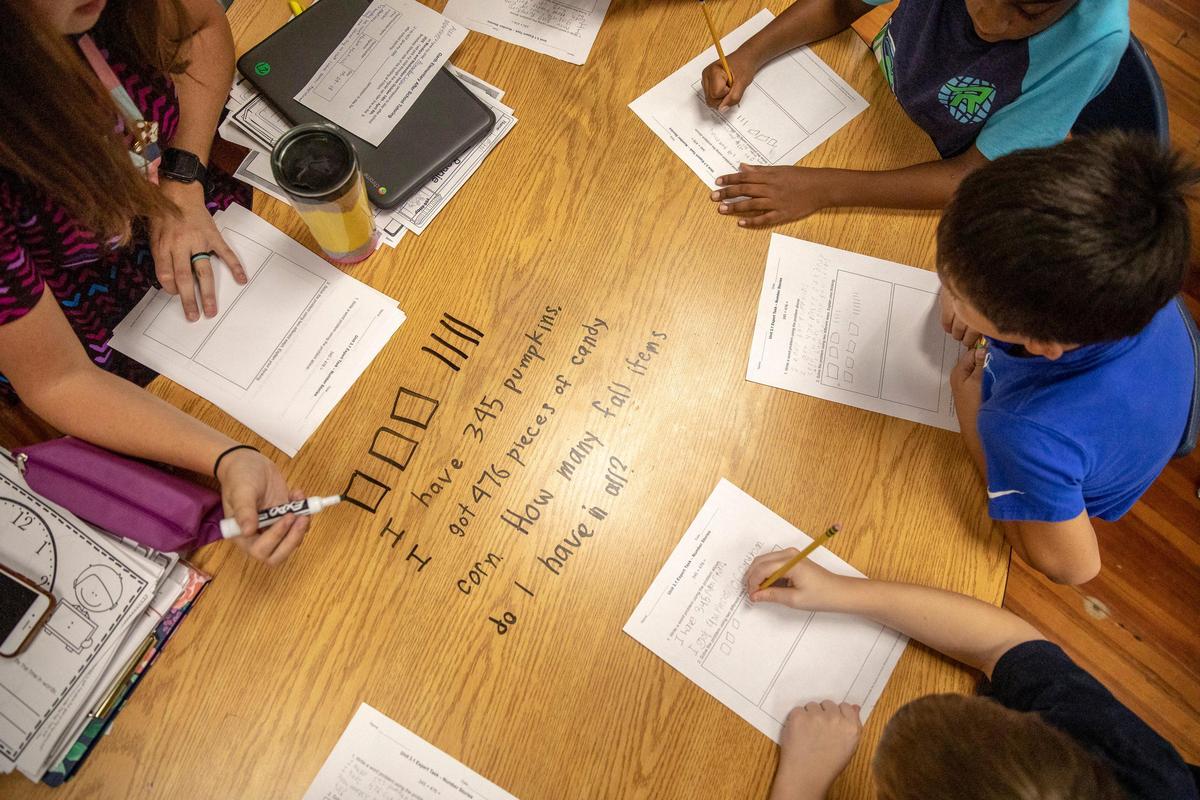 Teacher Taylor Knoblett works with students in her third grade class at Garth Elementary School in Scott County on Monday. Garth was one of 20 schools to have at least a 10-point gain in proficiency from 2017-18 to 2018-19.
