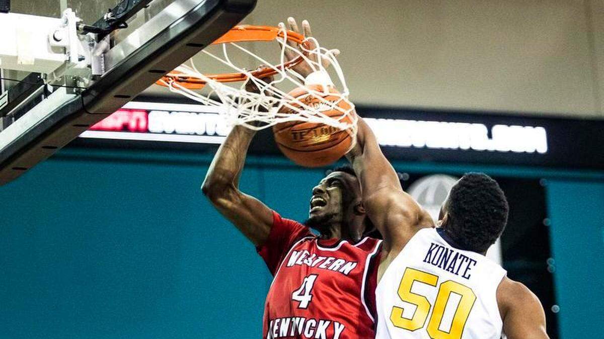 Western Kentucky guard Josh Anderson (4) dunks while guarded by West Virginia forward Sagaba Konate (50) during an NCAA college basketball game of the Myrtle Beach Invitational in Conway, S.C., Friday, Nov. 16, 2018. Western Kentucky won, 63-57.