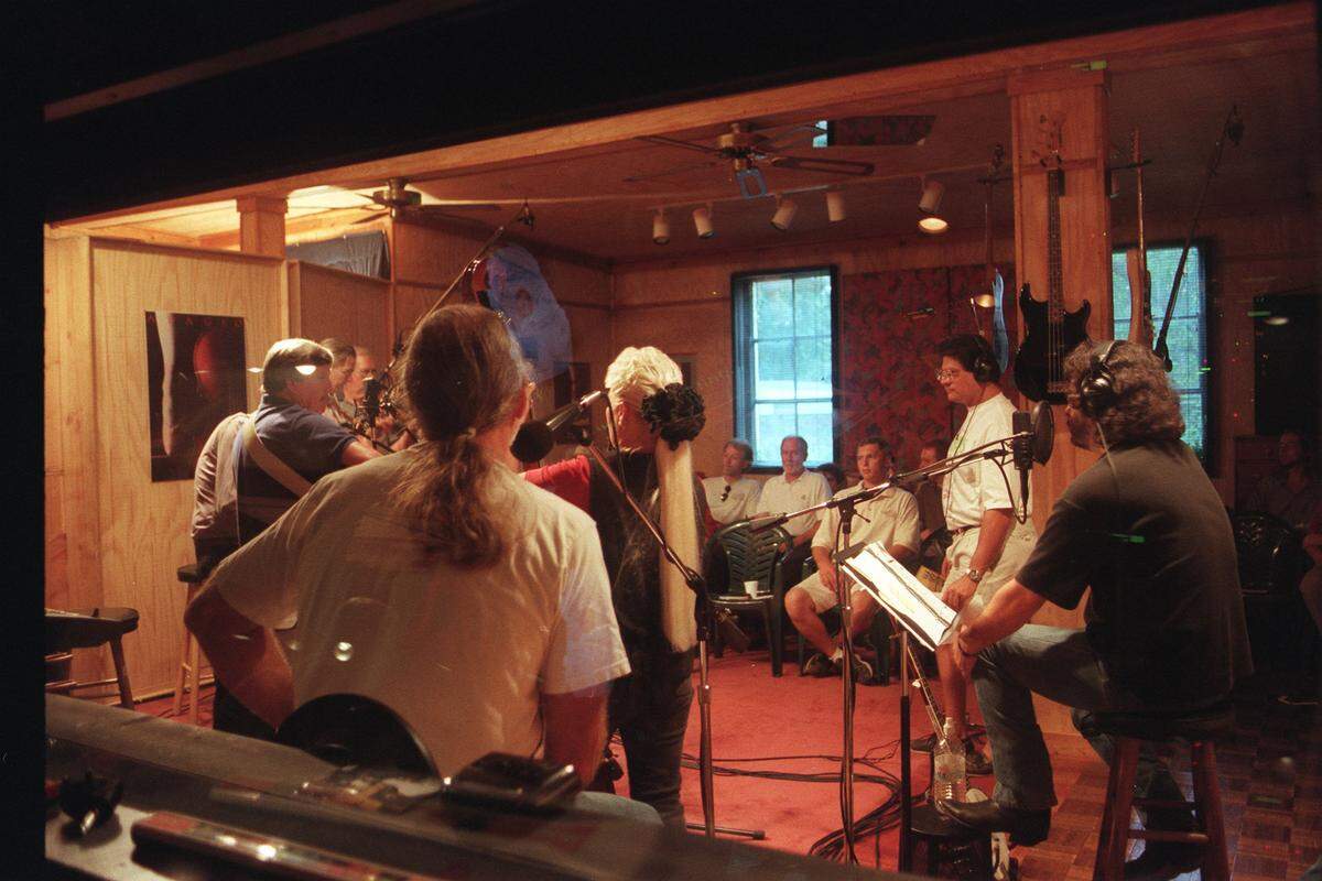 Michael Johnathon, far right, creator of the WoodSongs Old-Time Radio Hour, listens to the sounds of Homer Ledford, and the Cabin Creek Band during an Oct. 5, 1998 taping at Planet III studio. At this point the show had only been on the air for five months. Only about 50 people could fit in the North Broadway studio.