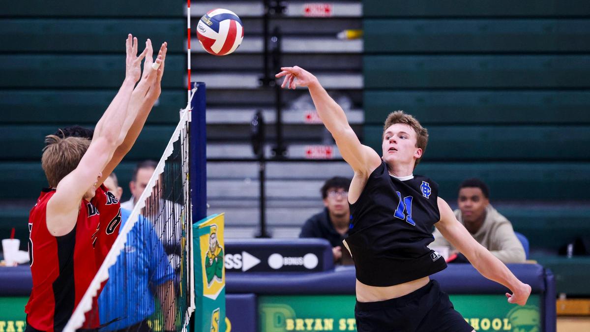 Henry Clay’s McAllister Millar (11) tips the ball over the Paul Laurence Dunbar defense during the Blue Devils’ 3-0 win in the 7th Region Boys Volleyball Tournament on Thursday at Bryan Station High School.