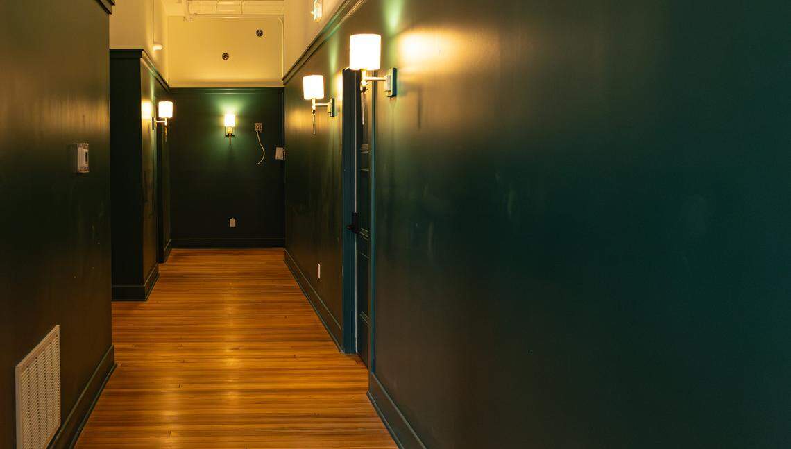 The hallways are painted Keeneland green, a traditional rich green paying homage to the horse race course's trees and turf, illuminated by golden sconce light fixtures at Hotel Thoroughbred, a 19-room boutique hotel undergoing restoration in downtown Paris, Ky, on Dec. 4, 2025.
