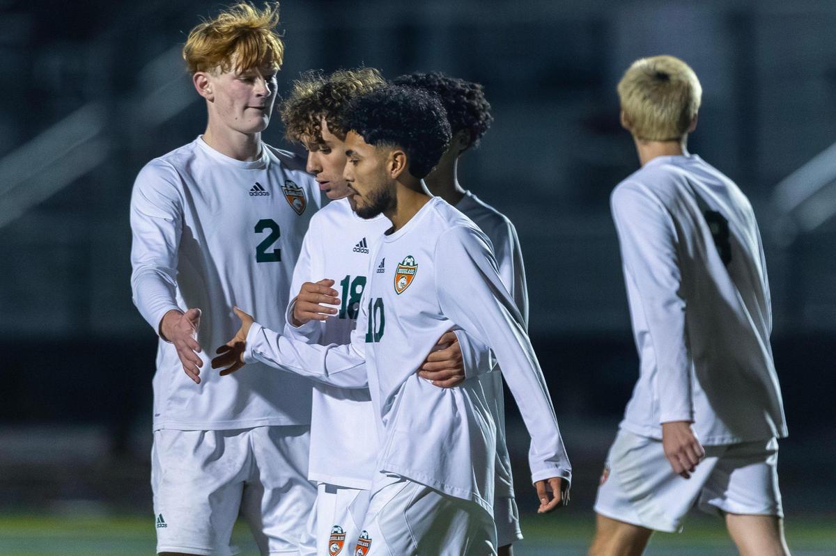 Frederick Douglass’ Juan Figueroa (10) is congratulated by his teammates after scoring a go-ahead goal on a penalty kick during the boys 11th Region tournament semifinals against Frankfort at Henry Clay High School on Wednesday.