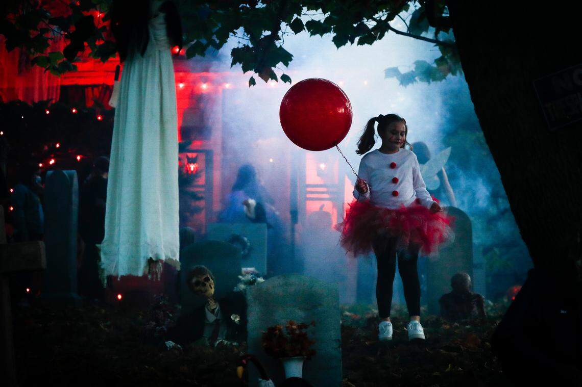 Kendall Pugh, 11, of Lexington, Ky., dressed as Pennywise from the movie “It,” stands in her grandparent’s yard waiting for trick-or-treaters in Lexington, Saturday, Oct. 31, 2020. Steve and Denise Mills have have been elaborately decorating their yard, which includes and haunted house, for Halloween every year for over two decades.