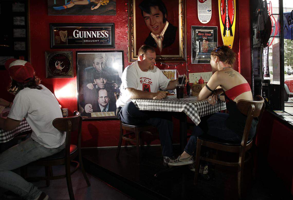Mike Wiley, center, tries a burger at Sidebar Grill in this file photo.