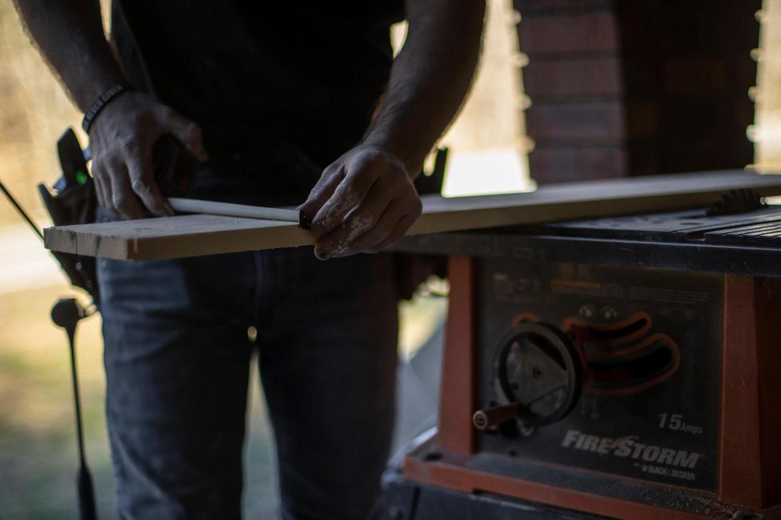 Shane Farmer cuts a board as he works to repair the home of his girlfriend’s mother near KY 476 in Eastern Kentucky. Flood waters last summer nearly reached the ceiling of the home.