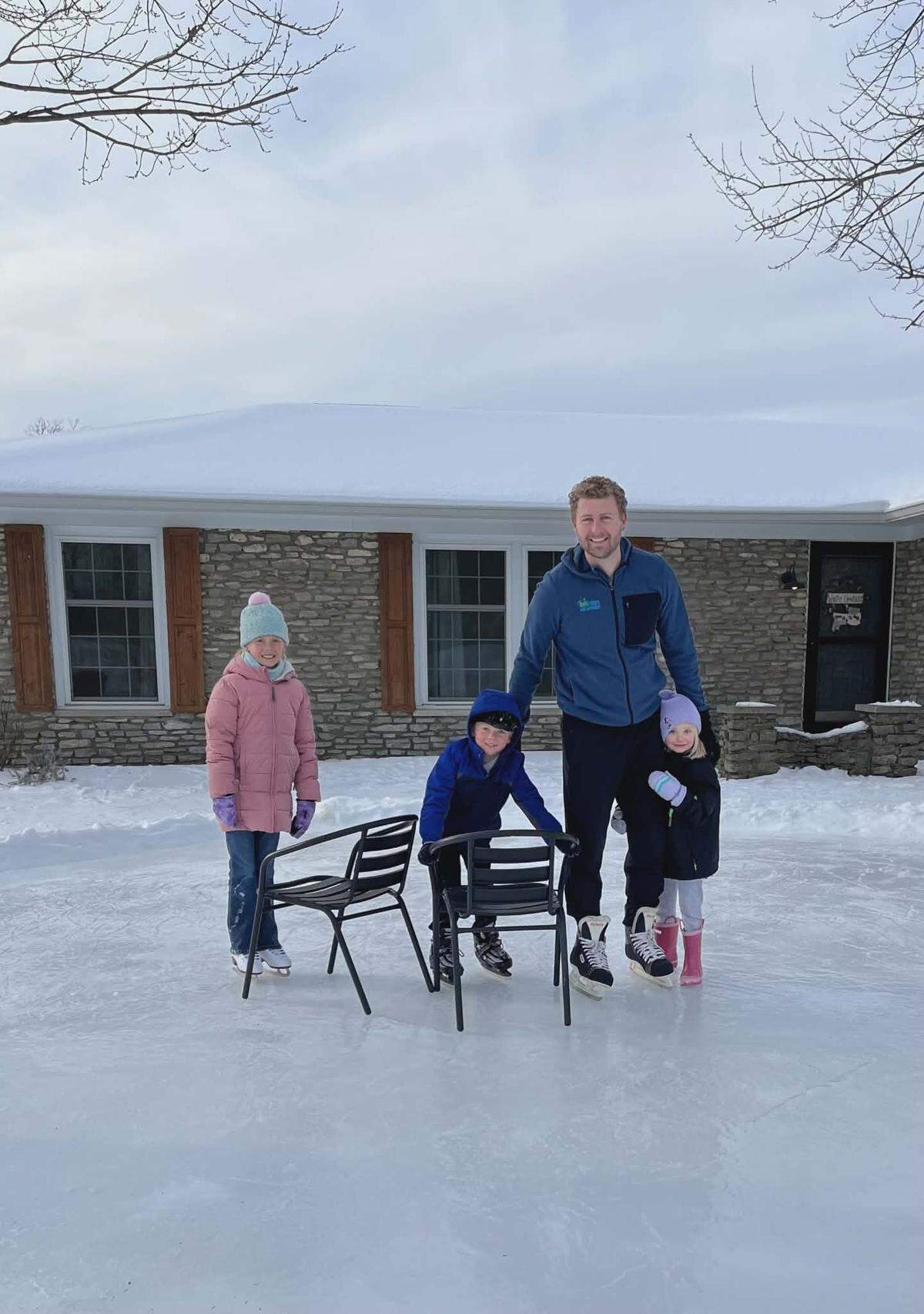 Jordan Hall (second from right) poses for a photo with his children on the homemade ice rink he created in his front yard.