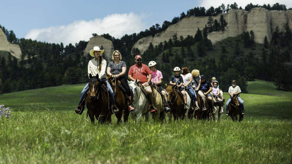 With the Red Cloud Buttes serving as the backdrop, a wrangler leads a trail ride at Fort Robinson State Park in Dawes County.