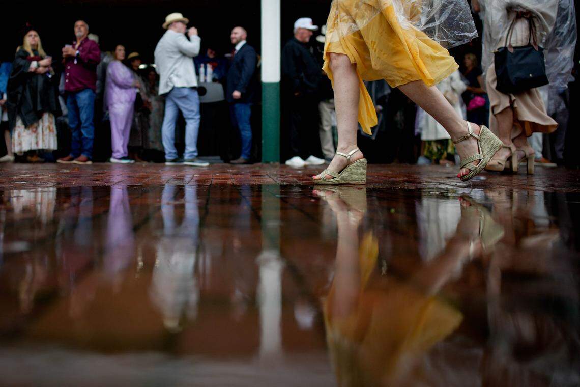 A woman walks thorough a puddle on the day of the 151th running of the Kentucky Derby at Churchill Downs.