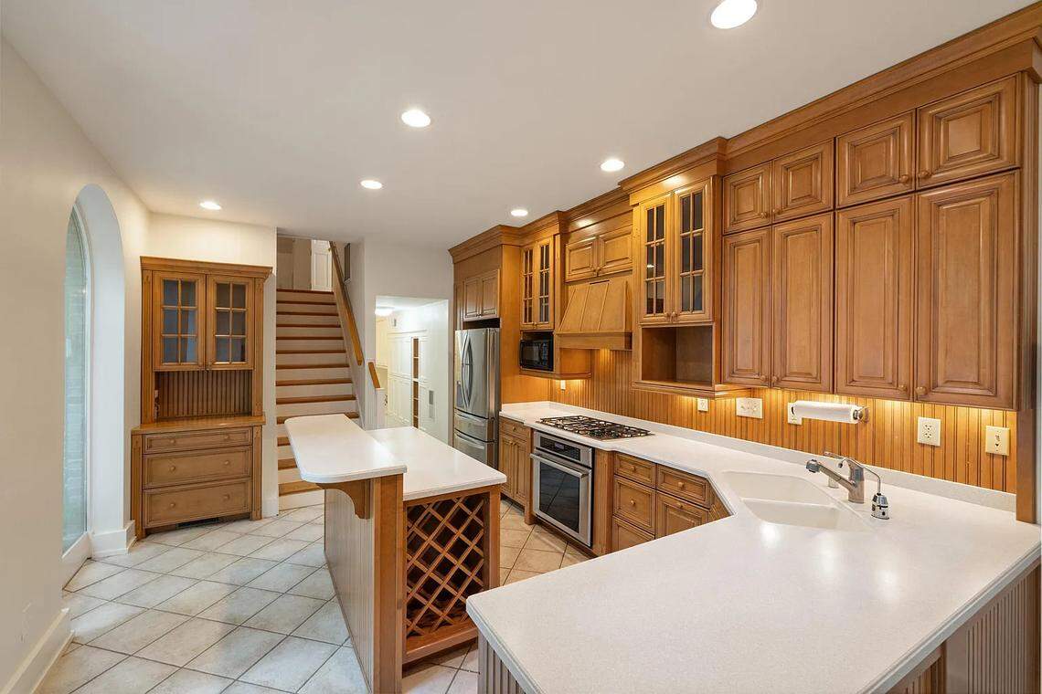 A view of the custom kitchen at 220 Market Street in Lexington. The countertops are white with cherry wooden cabinets.