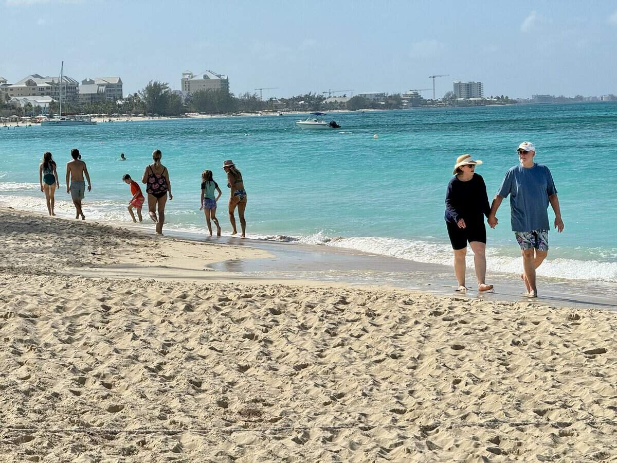 Tourists enjoy a day at Seven Mile Beach on Grand Cayman, the largest isle of the British possession of the Cayman Islands, on February 11, 2024. (Photo by Daniel SLIM / AFP) (Photo by DANIEL SLIM/AFP via Getty Images)