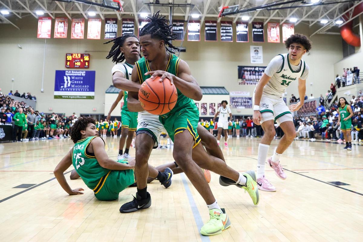 Bryan Station’s Amari Owens (5) dribbles around Great Crossing’s LJ Holman (0) during the 11th Region Tournament semifinals at Paul Laurence Dunbar High School’s S.T. Roach Sports Center on Saturday.