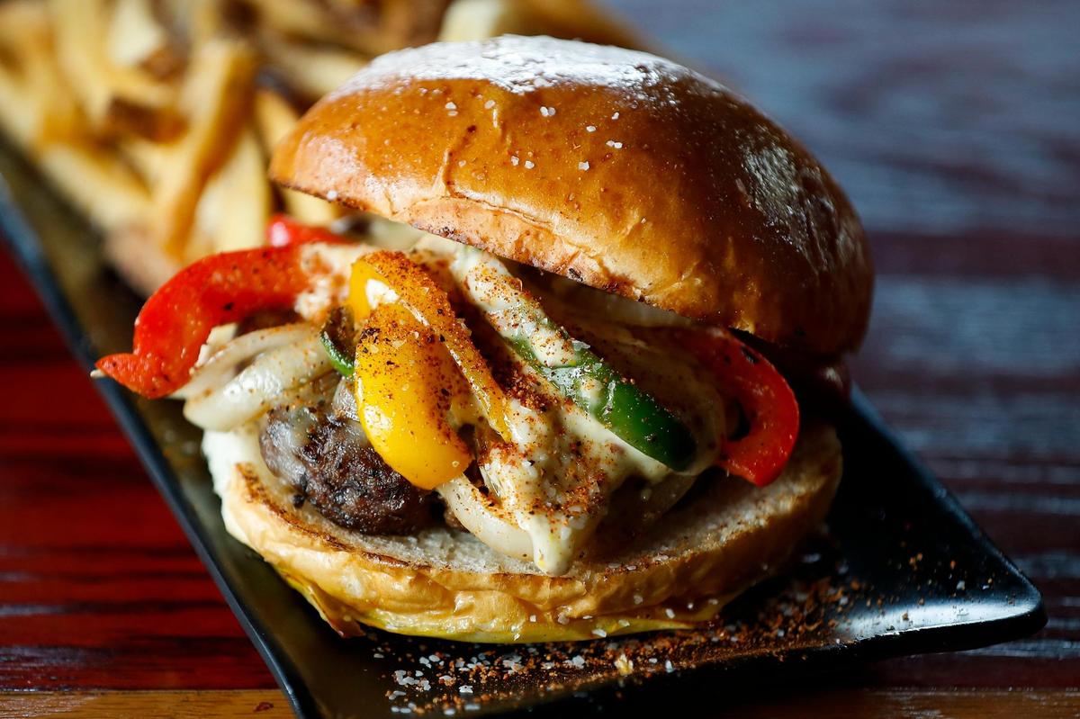 The Cajun Burger made with a six-ounce seasoned beef patty, grilled onions and peppers, pepper jack cheese, creole aioli and served on a brioche bun at Bad Wolf Burgers.