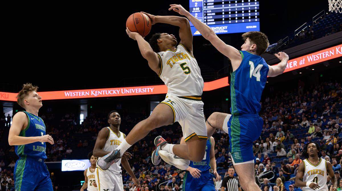 St. Xavier's Joshua Lindsay drives to the basket, guarded by North Laurel's Corey Cunagin during the first half of the UK HealthCare Boys' Basketball Sweet 16 state tournament quarterfinals matchup between the St. Xavier Tigers and the North Laurel Jaguars at Rupp Arena in Lexington, Ky, on March 20, 2026.