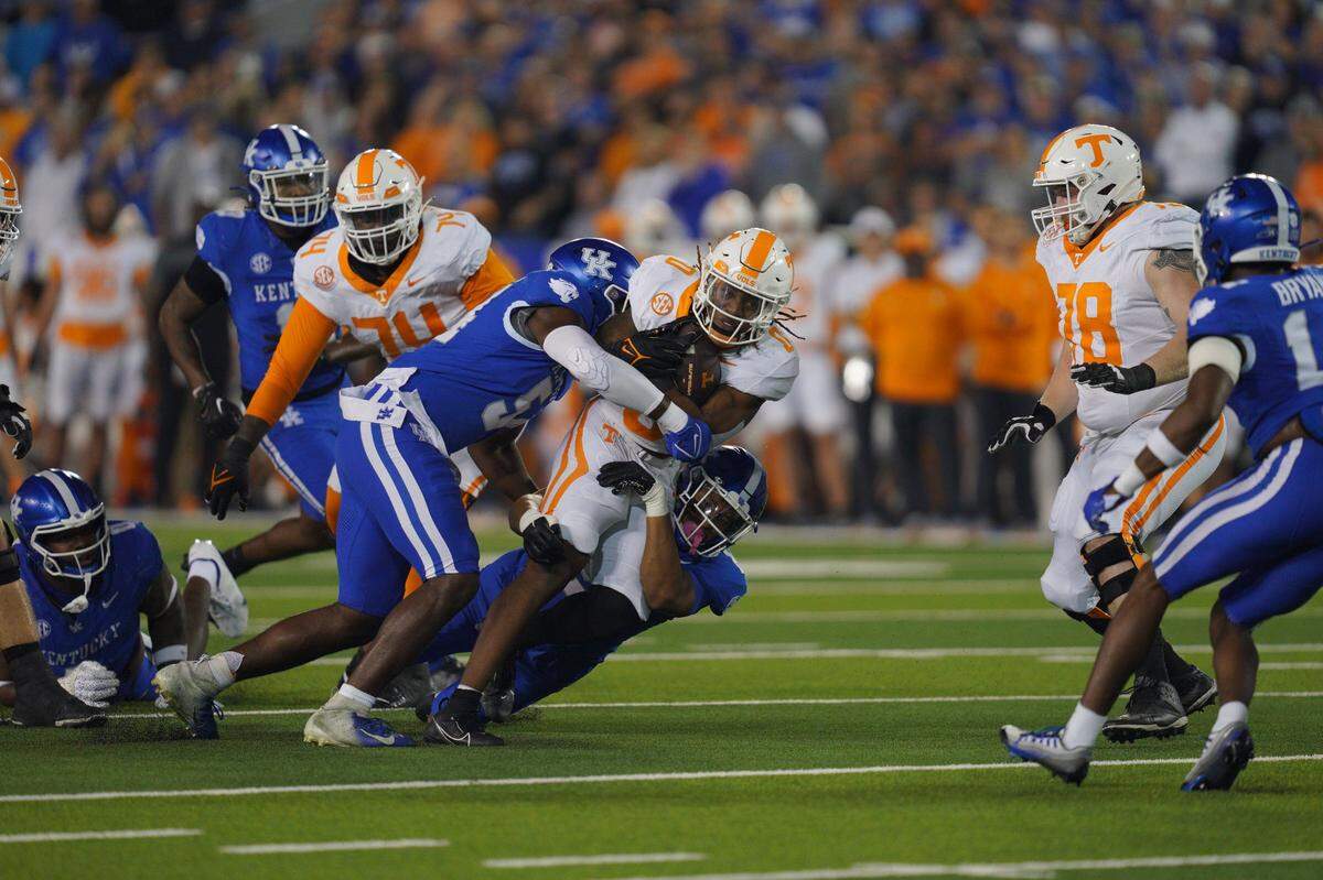 Kentucky linebacker D’Eryk Jackson (54) and Keaten Wade bring down Tennessee running back Jaylen Wright during Saturday’s game. Wright had 11 carries for 120 yards, including a 52-yard TD.