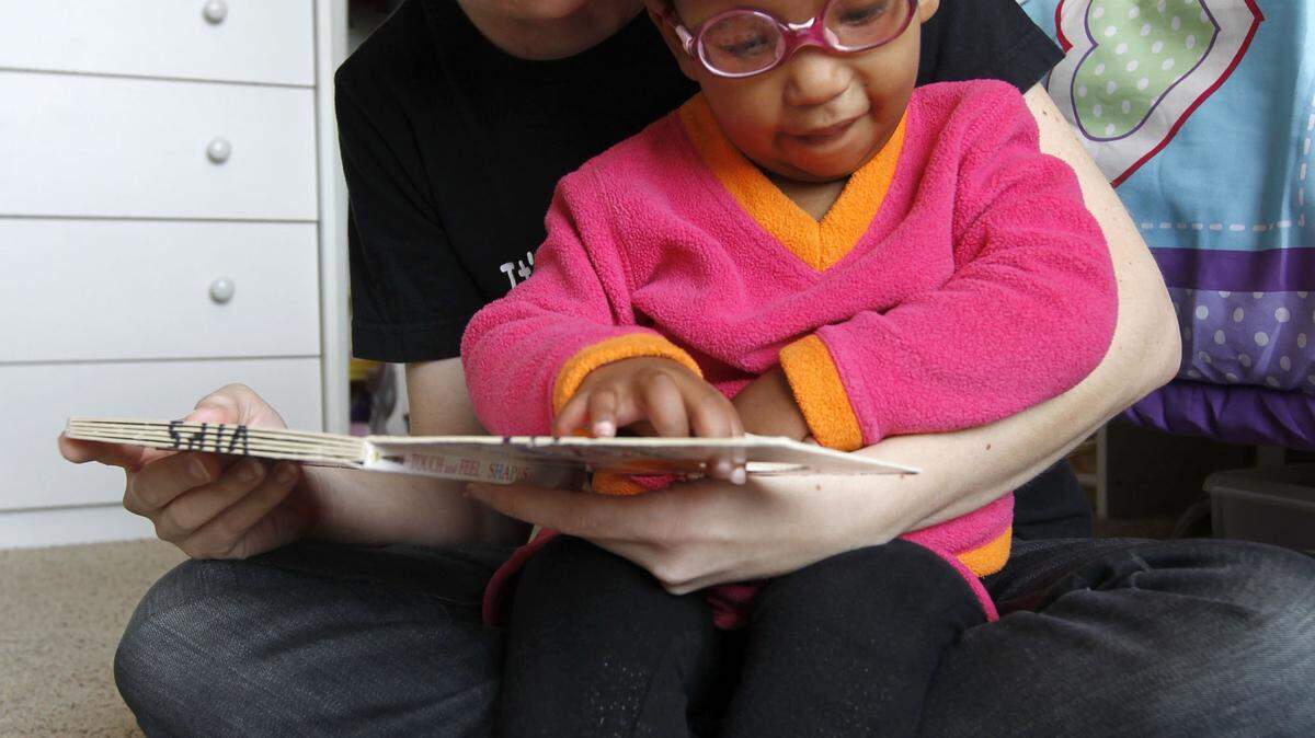 Rebecca Maas of Nicholasville read with daughter Sera, 2, from a Braille book provided by Visually Impaired Preschool  Services. It works with the Braille training program at the federal prison in Lexington to have children's books transcribed.   