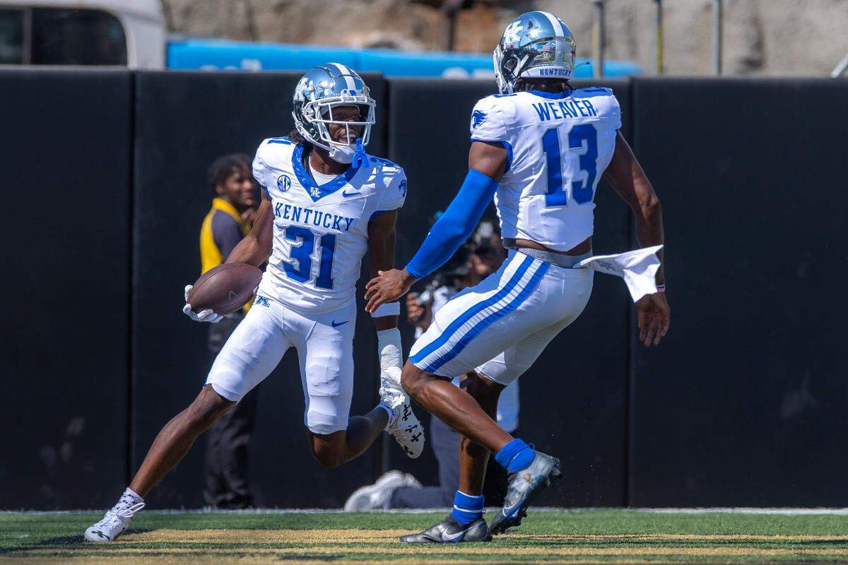 Kentucky’s Maxwell Hairston (31) celebrates with teammate J.J. Weaver (13) after returning an interception for a touchdown at FirstBank Stadium in Nashville on Saturday.
