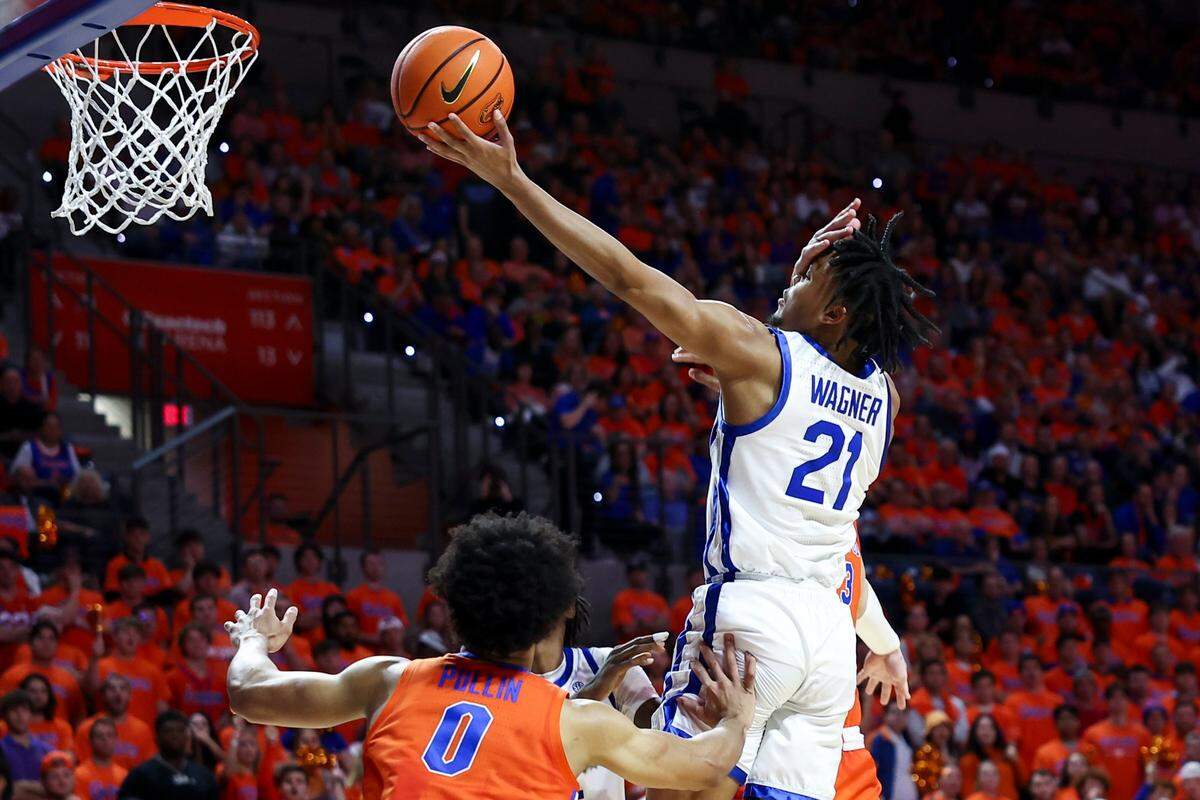 Kentucky guard D.J. Wagner (21) shoots the ball with the arm of Florida center Micah Handlogten in his face during Saturday’s game. Wagner had 14 points and three assists for the Wildcats.