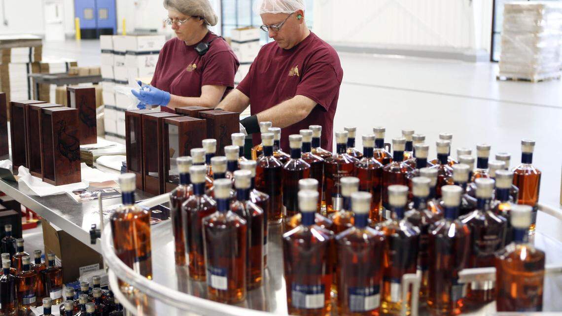 Charlene Dillow, left, and Ron Bennett, right, placed the bottles in wooden boxes as Wild Turkey Diamond was bottled at the distillery located on U.S. 62 at the Kentucky River near Lawrenceburg, Ky., Friday, April 11, 2014. Wild Turkey parent Campari is said to be planning lay offs.