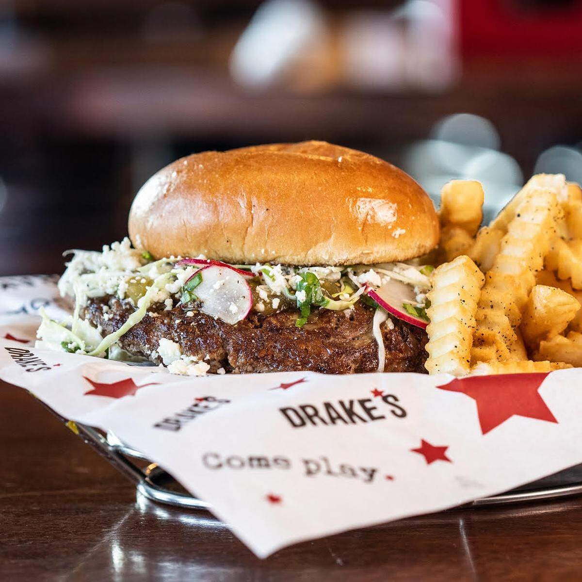 Drakes at Lansdowne’s Street Taco Burger, made with taco seasoning, cotija cheese, shaved radish, cabbage, salsa verde, cilantro and lime juice on a butter-toasted bun.