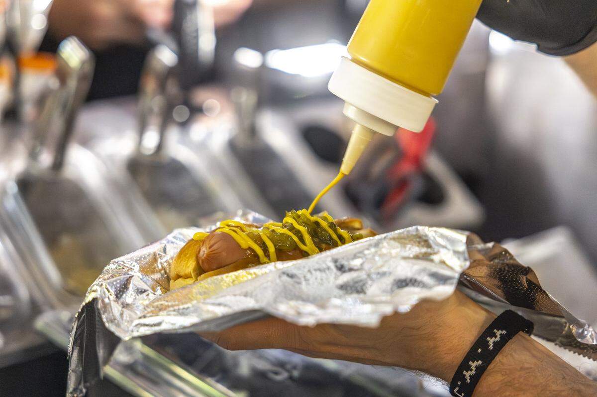Chris Price, the owner and operator of Big Blue Wiener, prepares a hot dog for a customer at his stand near Henry A. Tandy Centennial Park in downtown Lexington, Ky., in the early hours of Sunday, Sept. 14, 2025.