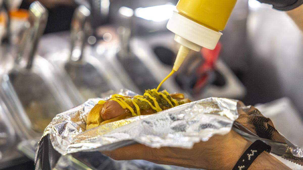 Chris Price, the owner and operator of Big Blue Wiener, prepares a hot dog for a customer at his stand near Henry A. Tandy Centennial Park in downtown Lexington, Ky., in the early hours of Sunday, Sept. 14, 2025.  