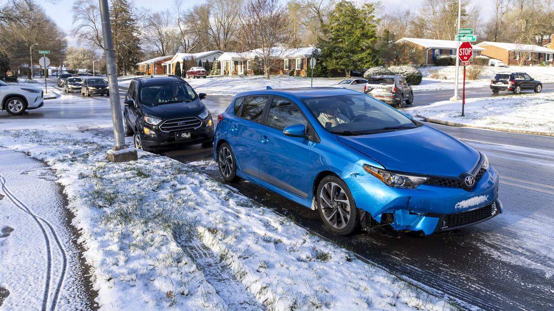 Two vehicles involved in an accident are off to the side of the road as traffic goes around them at the intersection of Gainesway Drive and Greentree Road, Tuesday, March 17, 2026 in Lexington, Ky. Slippery road conditions caused many crashes across the city after winter weather moved through the area.