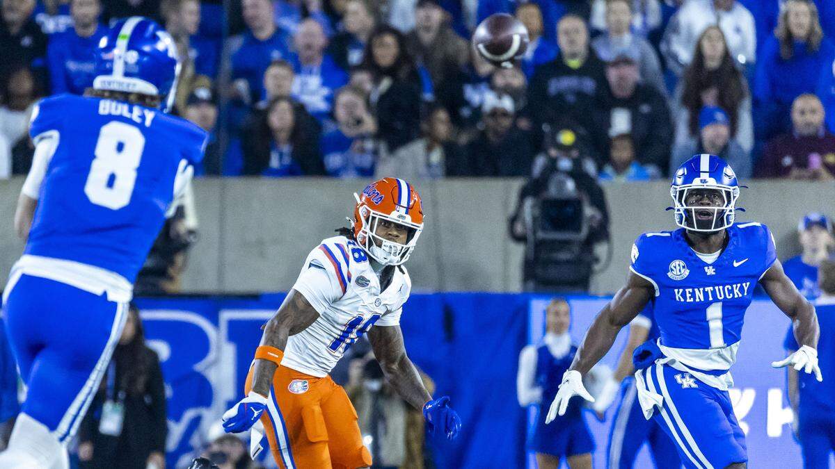 Kentucky wide receiver Kendrick Law (1) catches a pass thrown by quarterback Cutter Boley (8) as Florida safety Bryce Thornton (18) tries to defend.