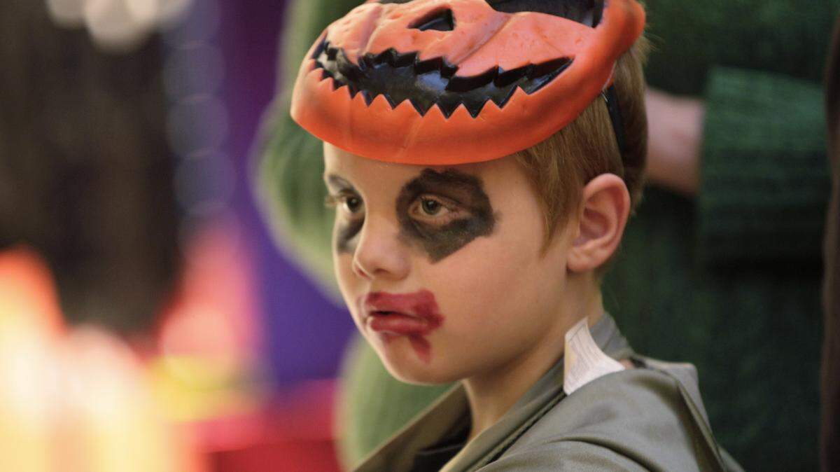 Richard Combs, 7, kept his blackened jack-o'-lantern eyes on the prize: candy at Fayette Mall.