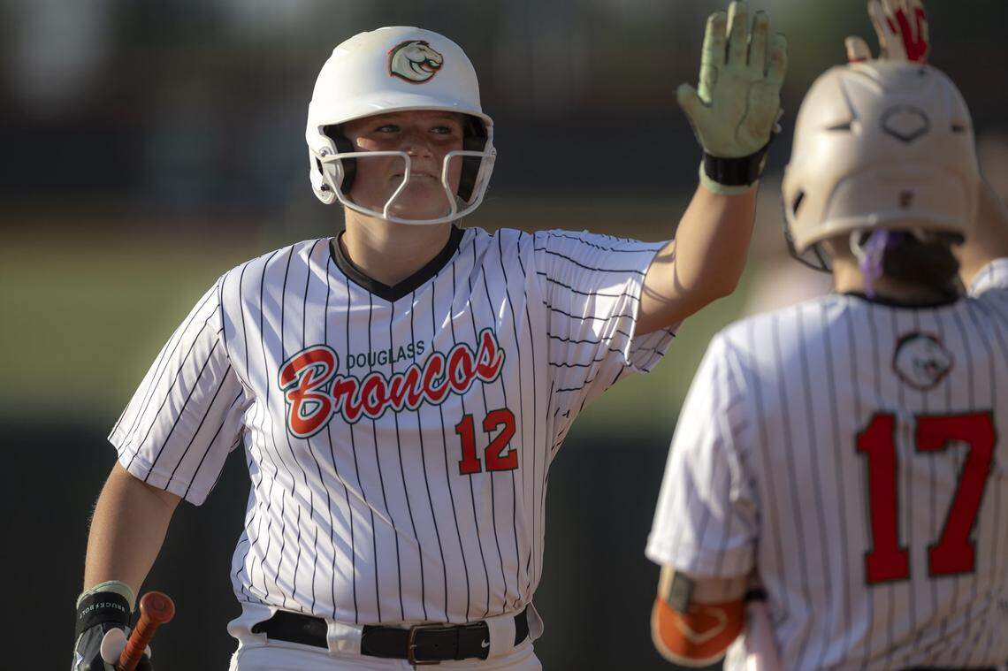 Frederick Douglass' Haley McGuire (12) high fives a teammate during a game against Lafayette at Frederick Douglass High School in Lexington, Ky., on Tuesday, April 14, 2026.