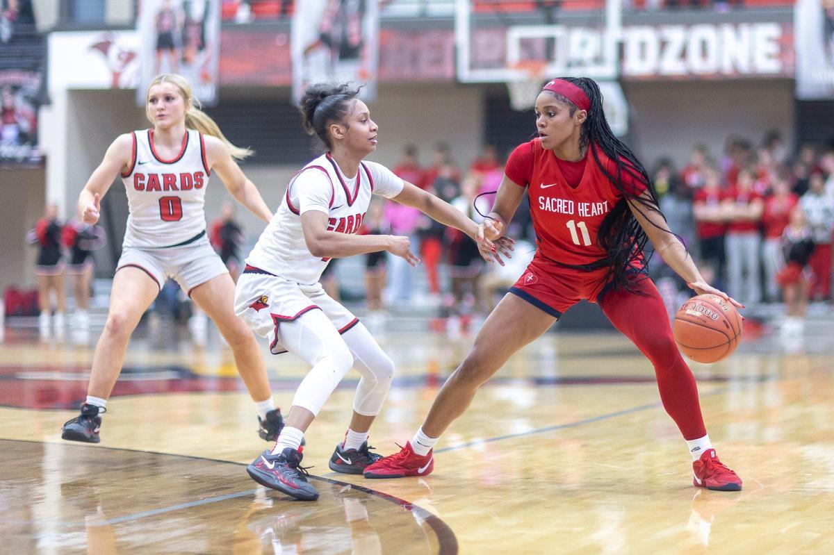 Sacred Heart’s ZaKiyah Johnson (11) looks for an opening against George Rogers Clark’s Jailenn Green during their game at GRC Arena in Winchester on Feb. 12.