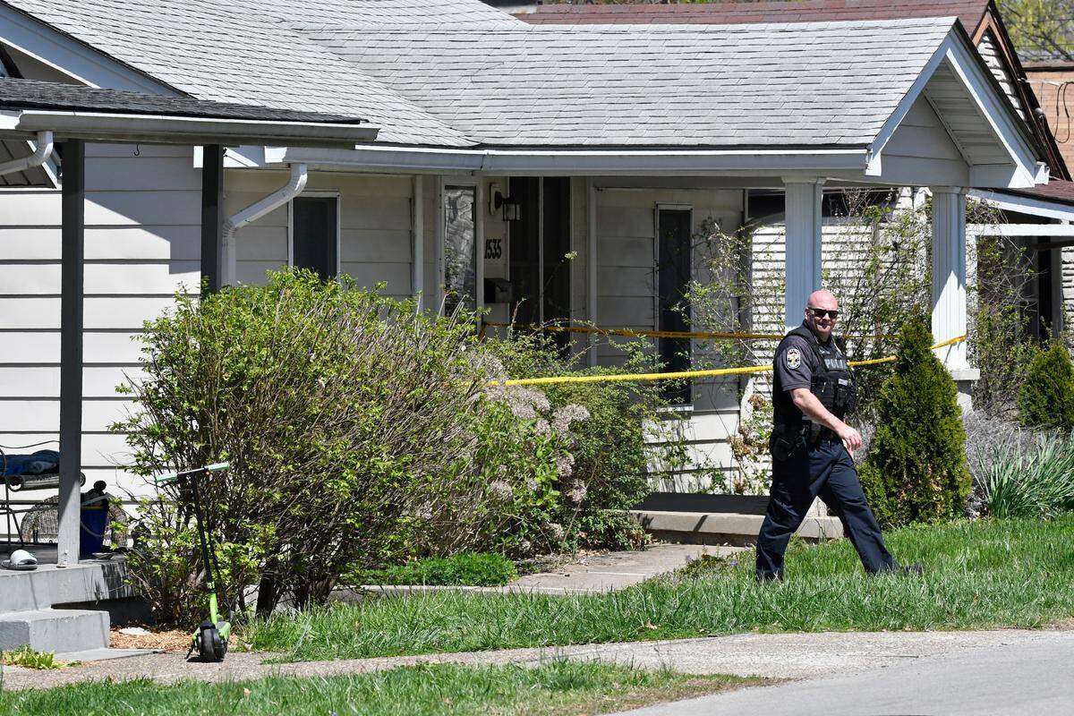 A Louisville Metro Police officer walks outside of the home of the suspected shooter in the Camp Taylor neighborhood in Louisville, Ky., Monday, April 10, 2023. Police say a 23-year-old armed with a rifle opened fire at his Louisville workplace, the Old National Bank in downtown Louisville, killing and wounding several, and was killed by police responding to the shooting.