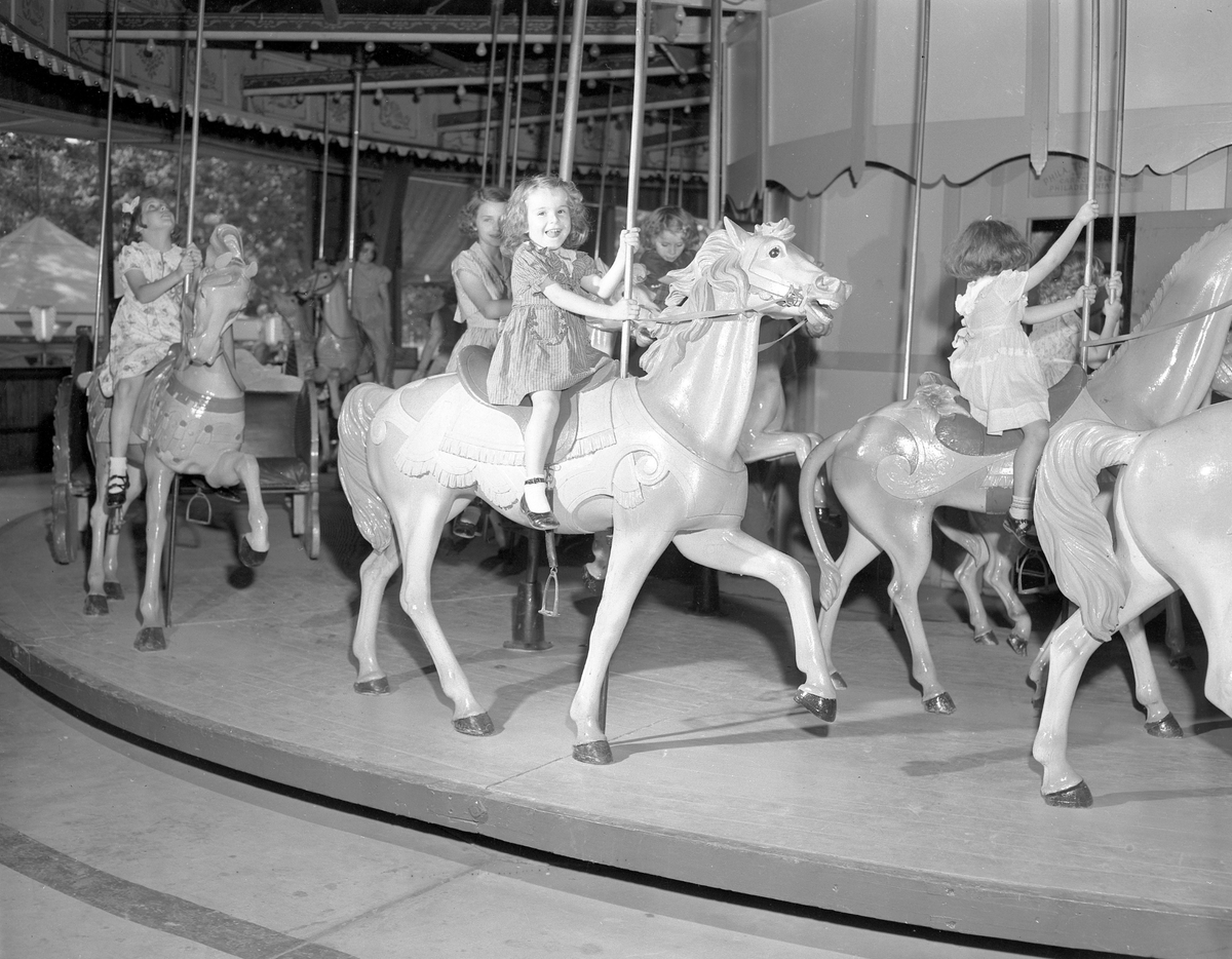 Picture of Linda Howard riding a carousel at Joyland Amusement Park.