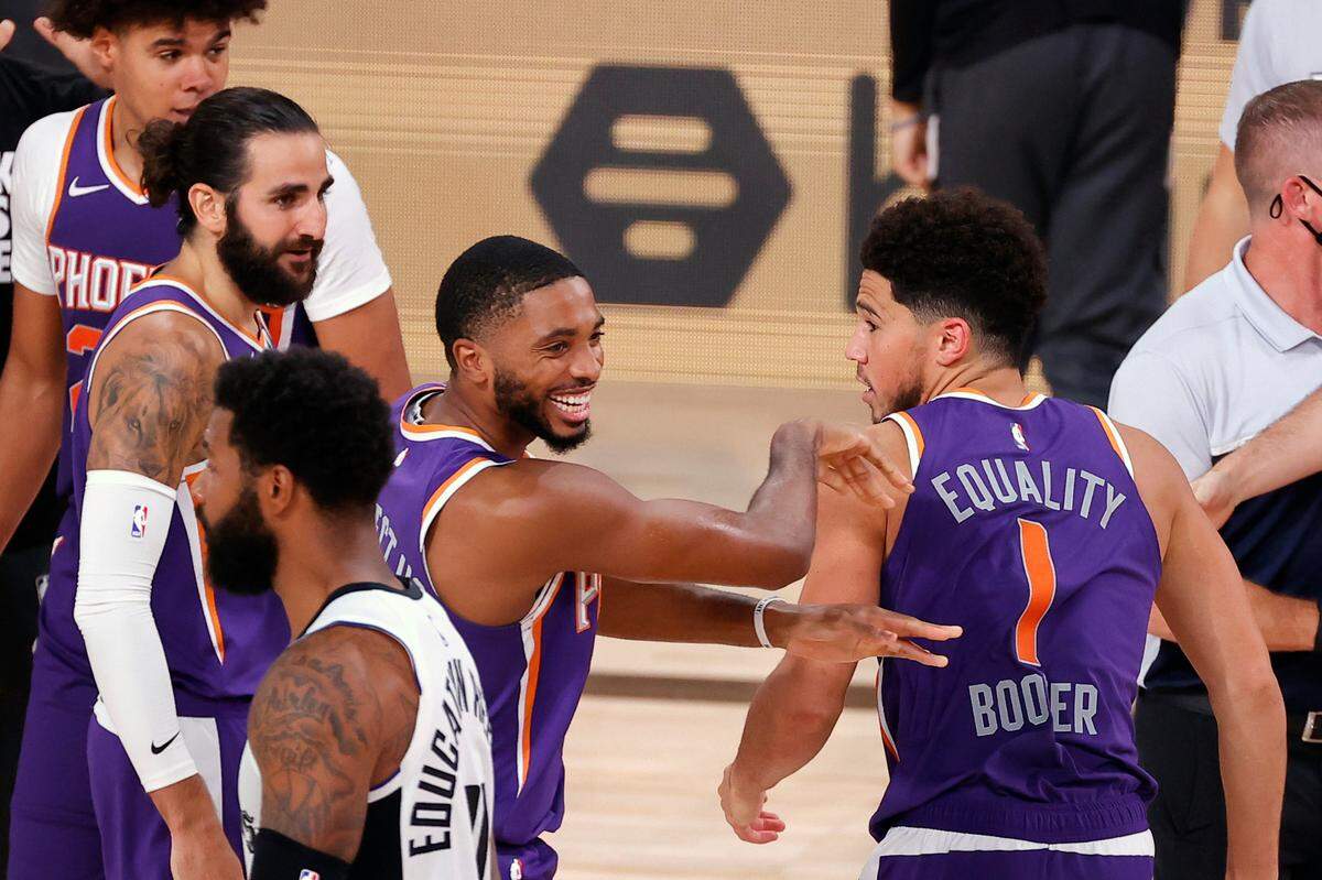 The Suns’ Devin Booker (1) celebrated with teammate Mikal Bridges after scoring the game-winning basket against the Clippers on Tuesday in Lake Buena Vista, Fla.