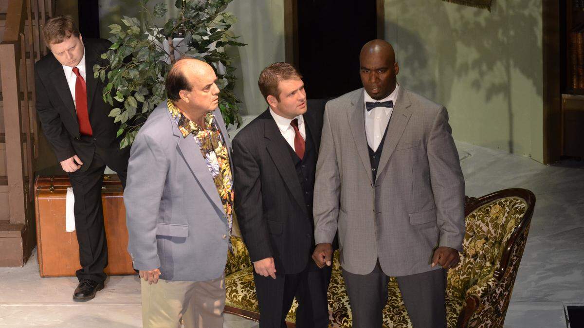 Krojack (Eric Forman) listens in as Walter (Bill Nichols), Axel (Than Cutler) and Kilroy (Mark Porter) discuss a hitch in their plans. Ragged Edge Community Theatre, 111 South Main Street in Harrodsburg, Kentucky, presents Woody Allen's 'Don't Drink the Water' on Aug. 21-30, 2015. Visit raggededgetheatre.net for more information. Herald-Leader photo by Rich Copley| rcopley@herald-leader.com.
