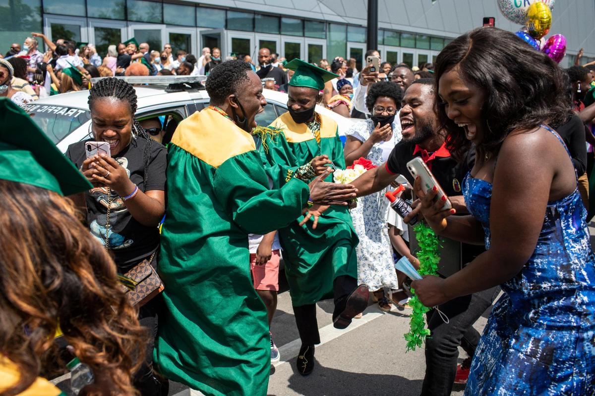 Samweli Kabura celebrates outside along High Street with his friends and family the graduation ceremony of Bryan Station High School at Rupp Arena in Lexington, Ky., Thursday May 20, 2021.