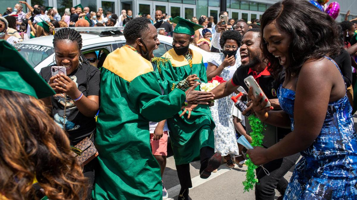 Samweli Kabura celebrates outside along High Street with his friends and family the graduation ceremony of Bryan Station High School at Rupp Arena in Lexington, Ky., Thursday May 20, 2021.
