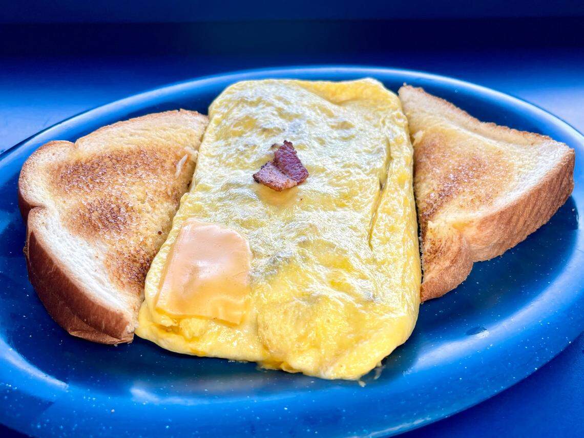 Tolly-Ho’s Bacon, Egg, and Cheese Omelet. Three-egg omelet, choice of cheese, and five pieces of bacon crumbled inside. Served with toast.