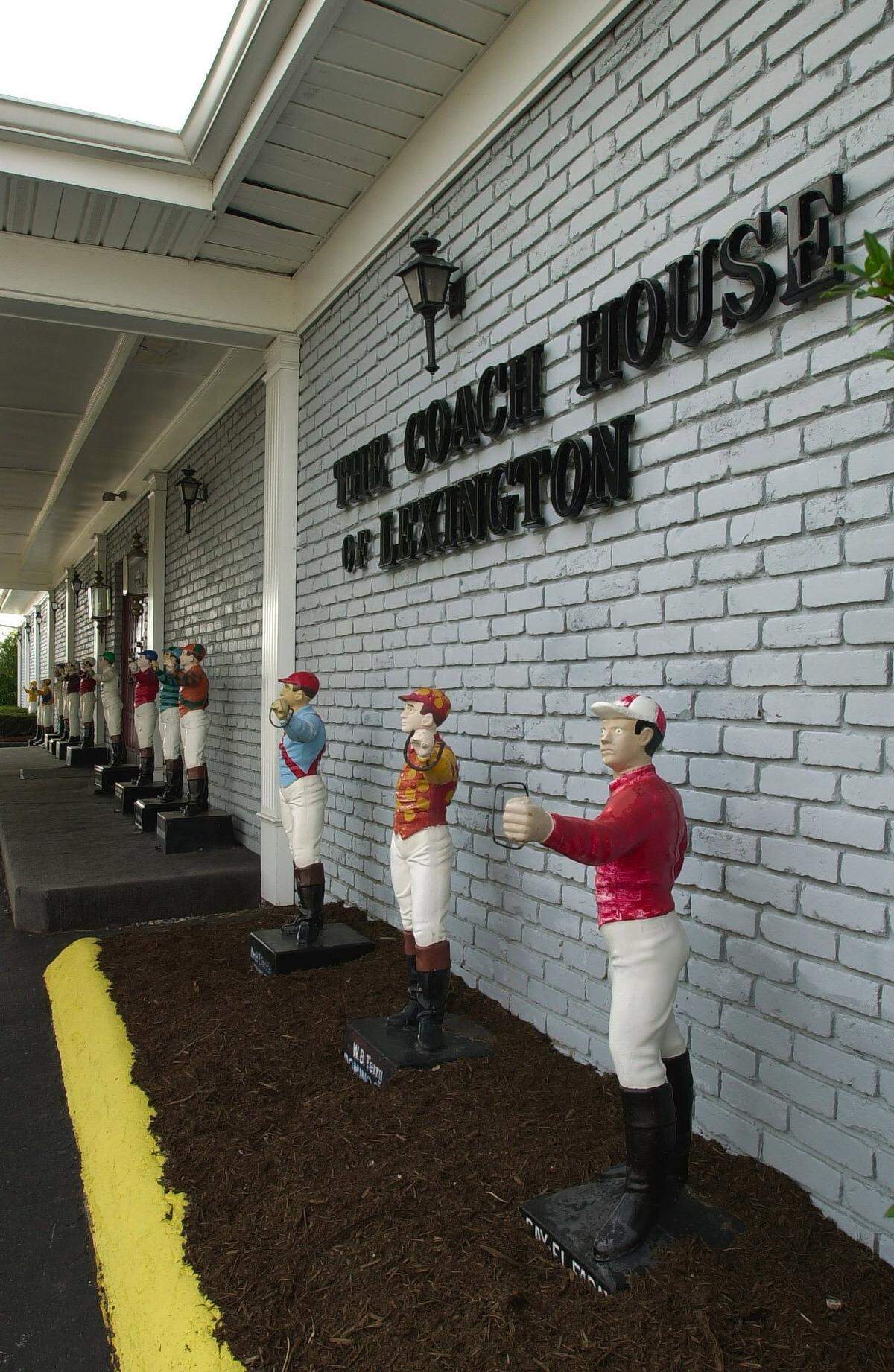 A row of lawn jockeys painted in racing colors outside the Coach House, which was torn down in 2013.
