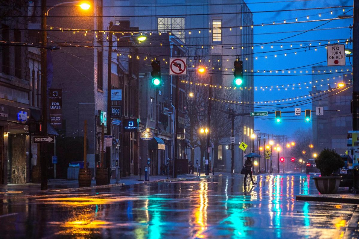 A pedestrian crosses Short Street in downtown Lexington during a rain shower Thursday, March 18, 2021.