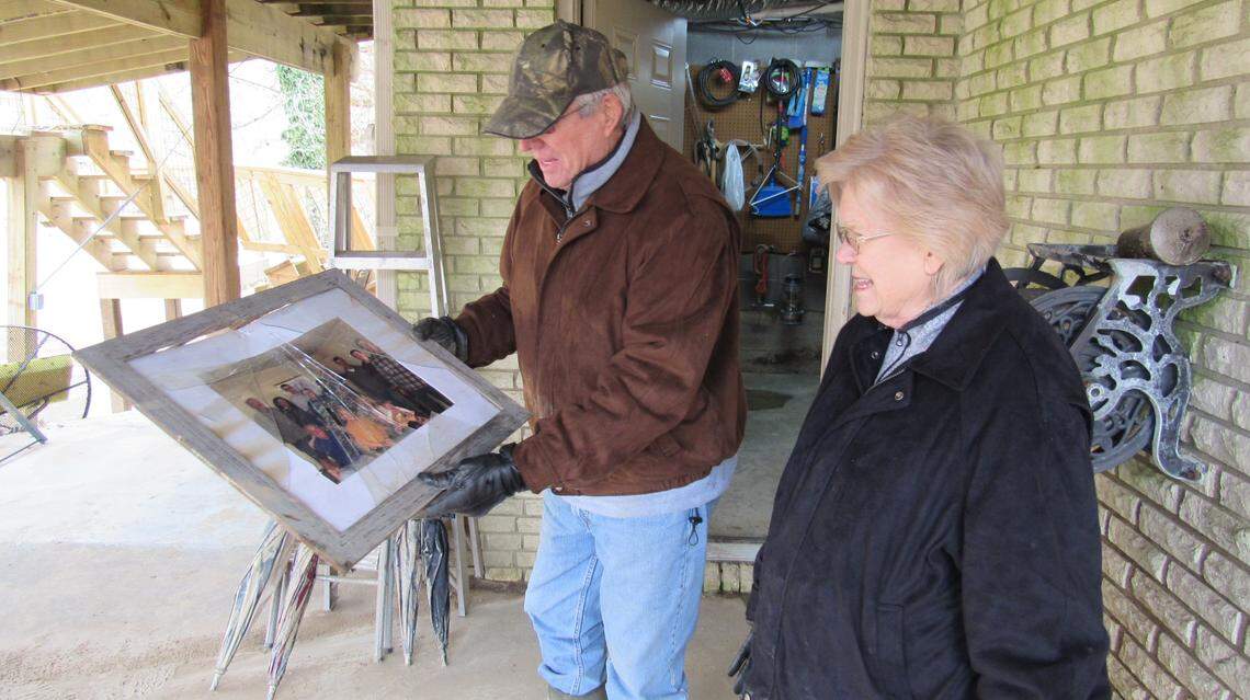 Charles Hall, left, showed his wife Juda a family photo on Feb. 17, 2025 as they discussed whether it could be salvaged after the lower level of their house in Hazard, Ky., flooded.