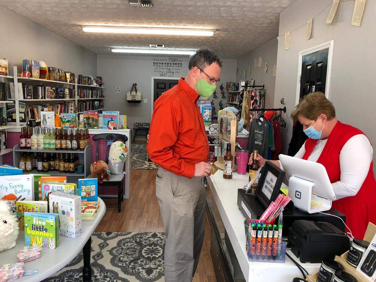 Cynthiana Mayor James Smith buys coffee syrup from Betty Faye Peak at The Next Chapter, an independent book store that opened last fall during the pandemic.