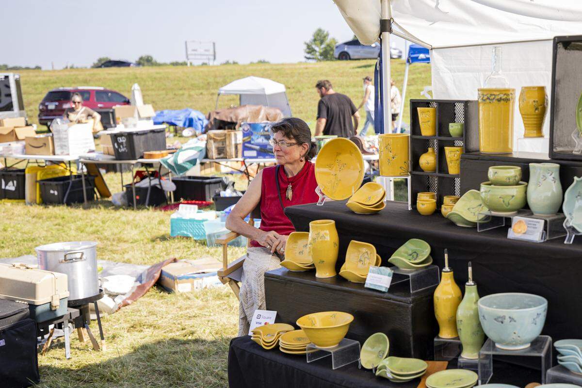 Marianne Brown, the mud lady, sits next to her pottery booth during the annual 127 Yard Sale on Friday, Aug. 8, 2025, in Lawrenceburg, Ky.