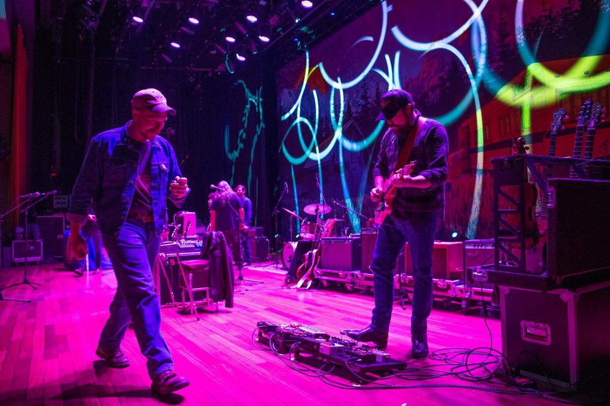 Tyler Childers walks past Jesse Wells during a sound check Friday, Feb. 7, 2020, at the Ryman Auditorium in Nashville, Tenn. Childers is in the middle of a two-weekend residency on the famous stage. Wells, a traditional music instructor at Morehead State Universiy, is a member of Chlilders band, The Foodstamps.
