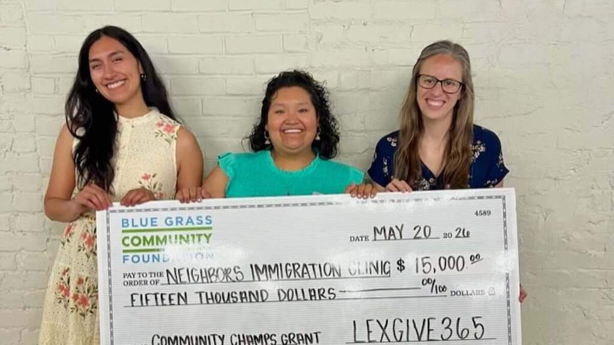 Idalia Flores, Mizari Suárez and Katie Taylor of Neighbors Immigration Clinic pose with a check after winning the LexGive365 Community Champions Grant on May 20, 2026.