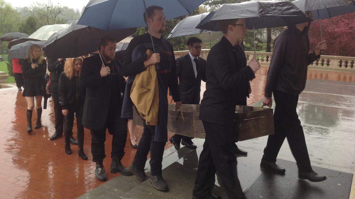 Protesters carried a casket up the steps of the Capitol in Frankfort on Monday. The protesters said the casket represents the EKU Theatre program which was eliminated due to funding cuts.