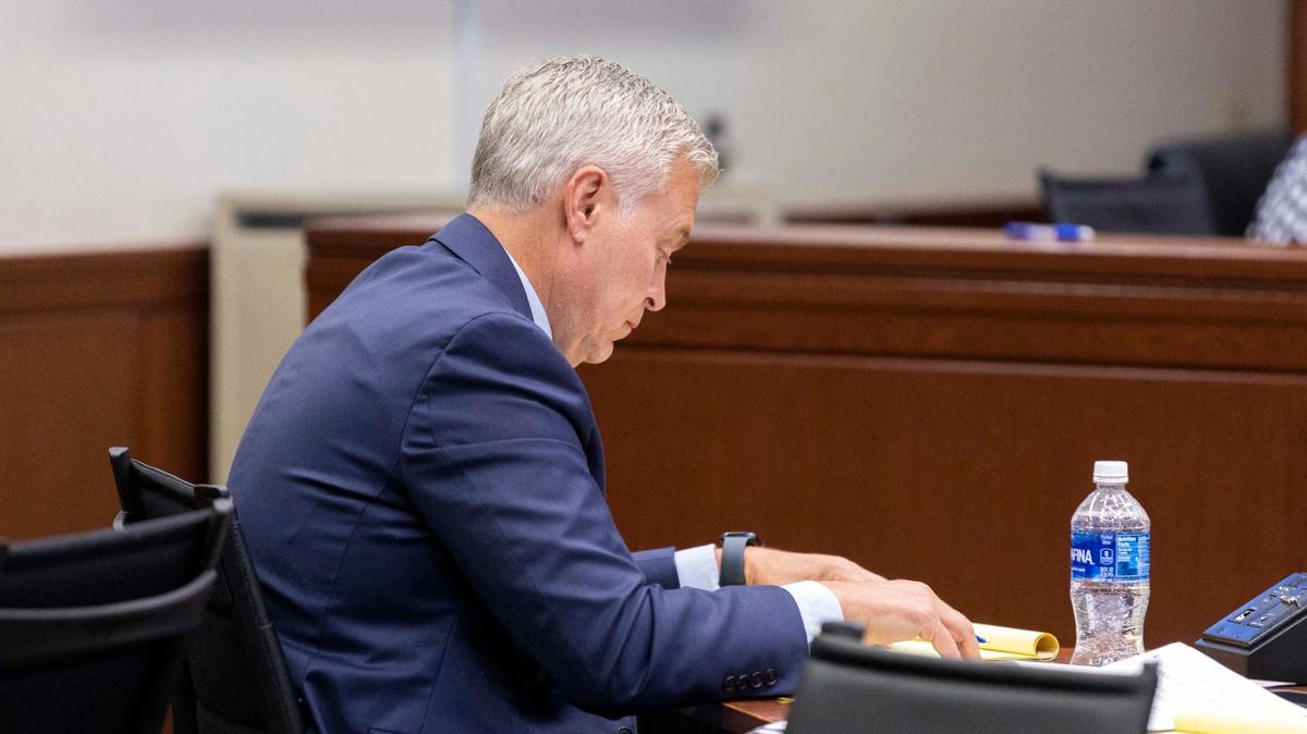 John Tilley, who is charged with rape, looks down at notes during his criminal trial.