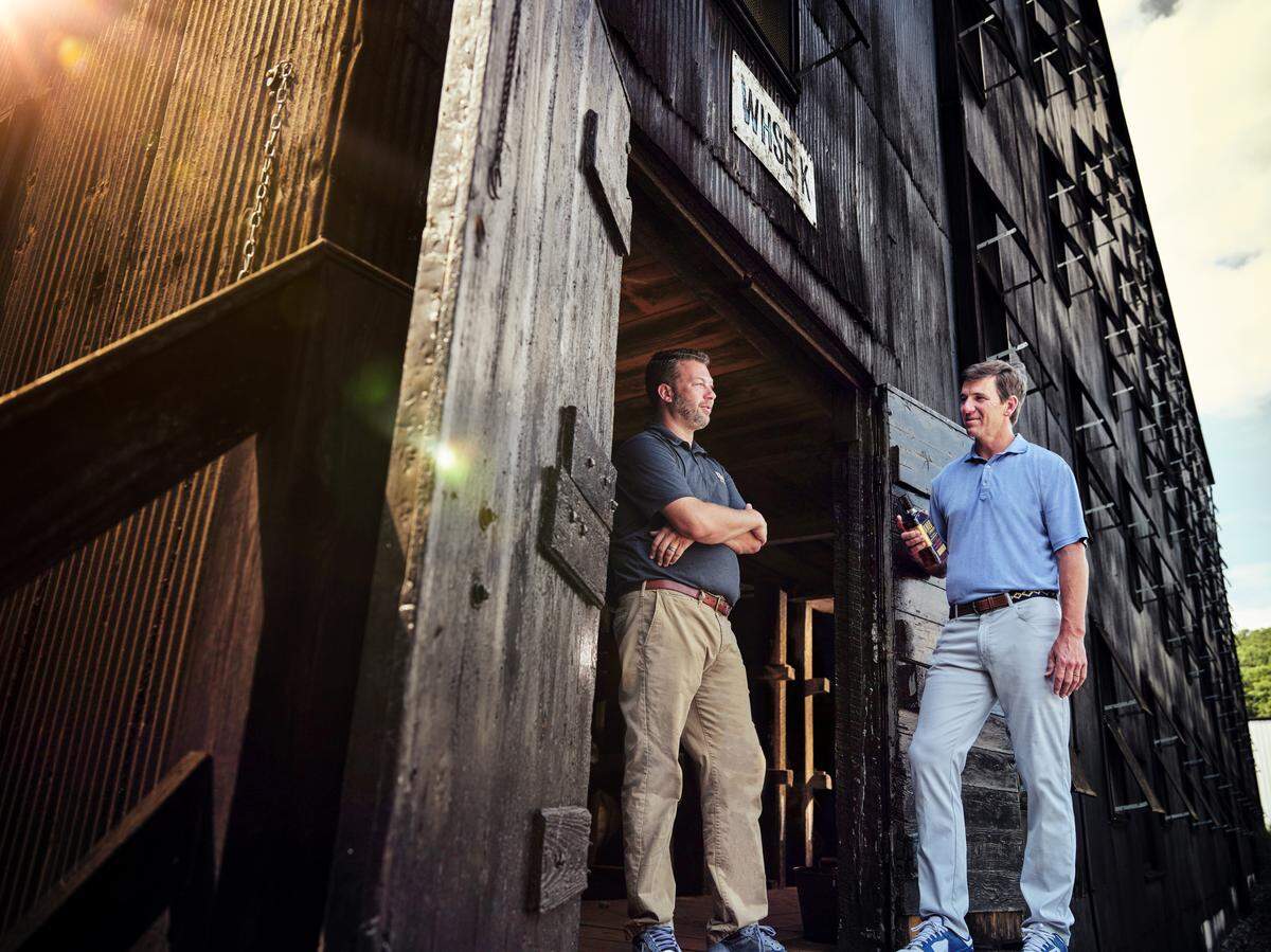 Former New York Giants quarterback Eli Manning, right, holding a bottle of his Knob Creek barrel pick, with Freddie Noe, James B. Beam master distiller.