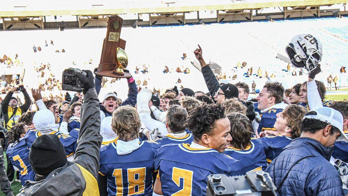 Sayre head coach Chad Pennington hoists the state championship trophy after his team’s Class A victory over Raceland at Kroger Field in Lexington on Friday.