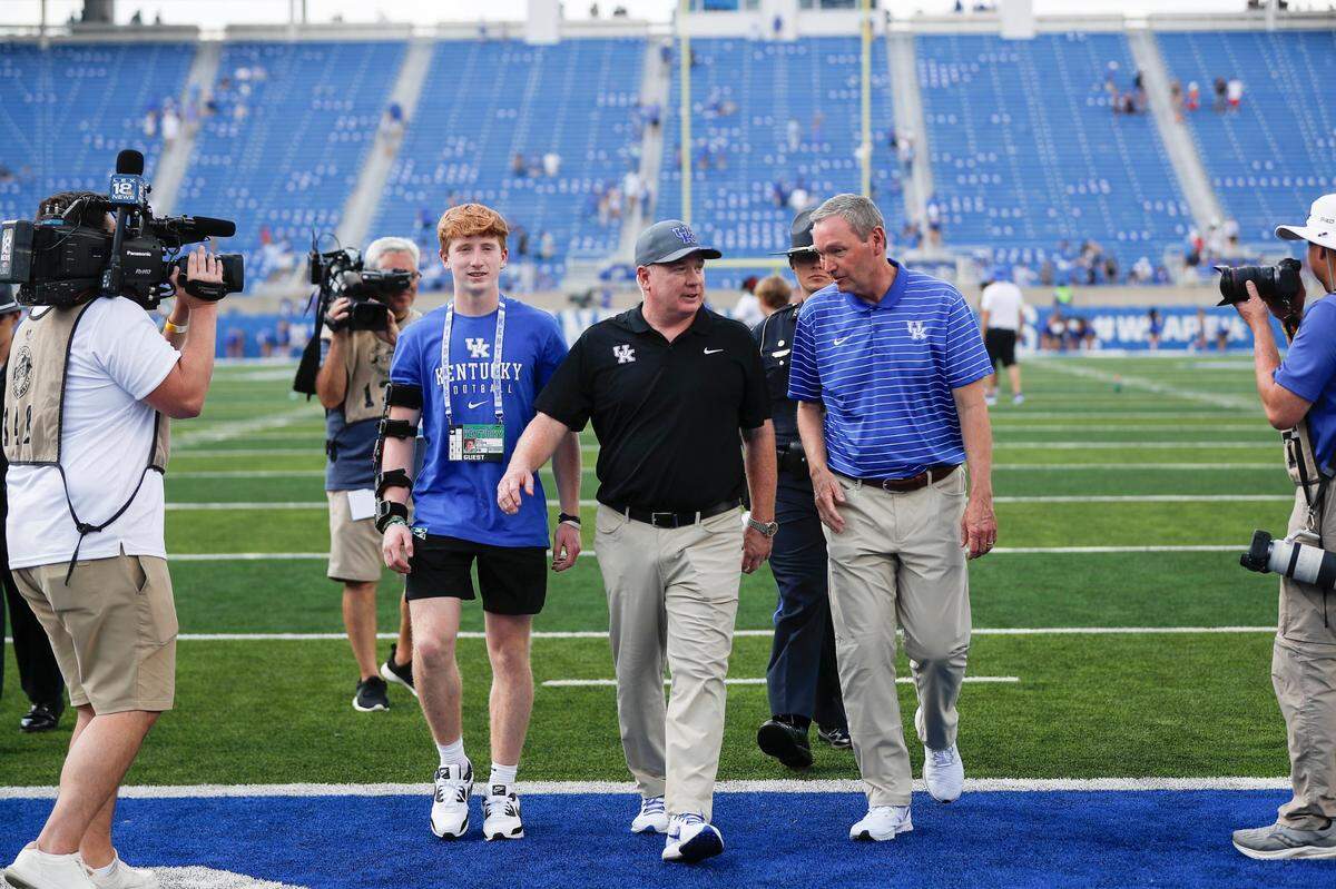 Kentucky football coach Mark Stoops, center, walked off the field with UK athletics director Mitch Barnhart, right, after the Wildcats blitzed Ball State 44-14 in the 2023 season opener at Kroger Field.